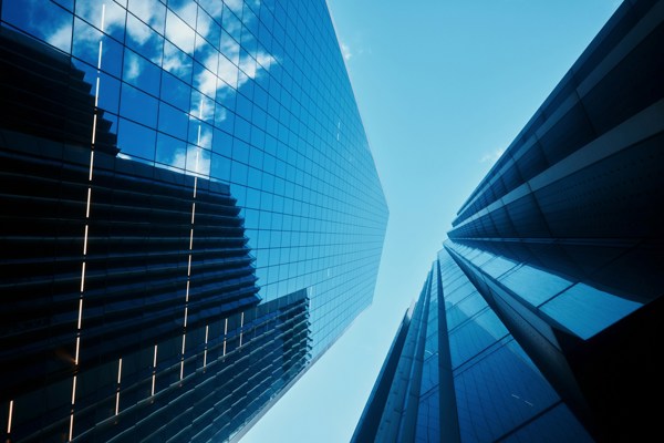 Modern glass office buildings viewed from below, representing the UK financial services sector and regulatory reform.