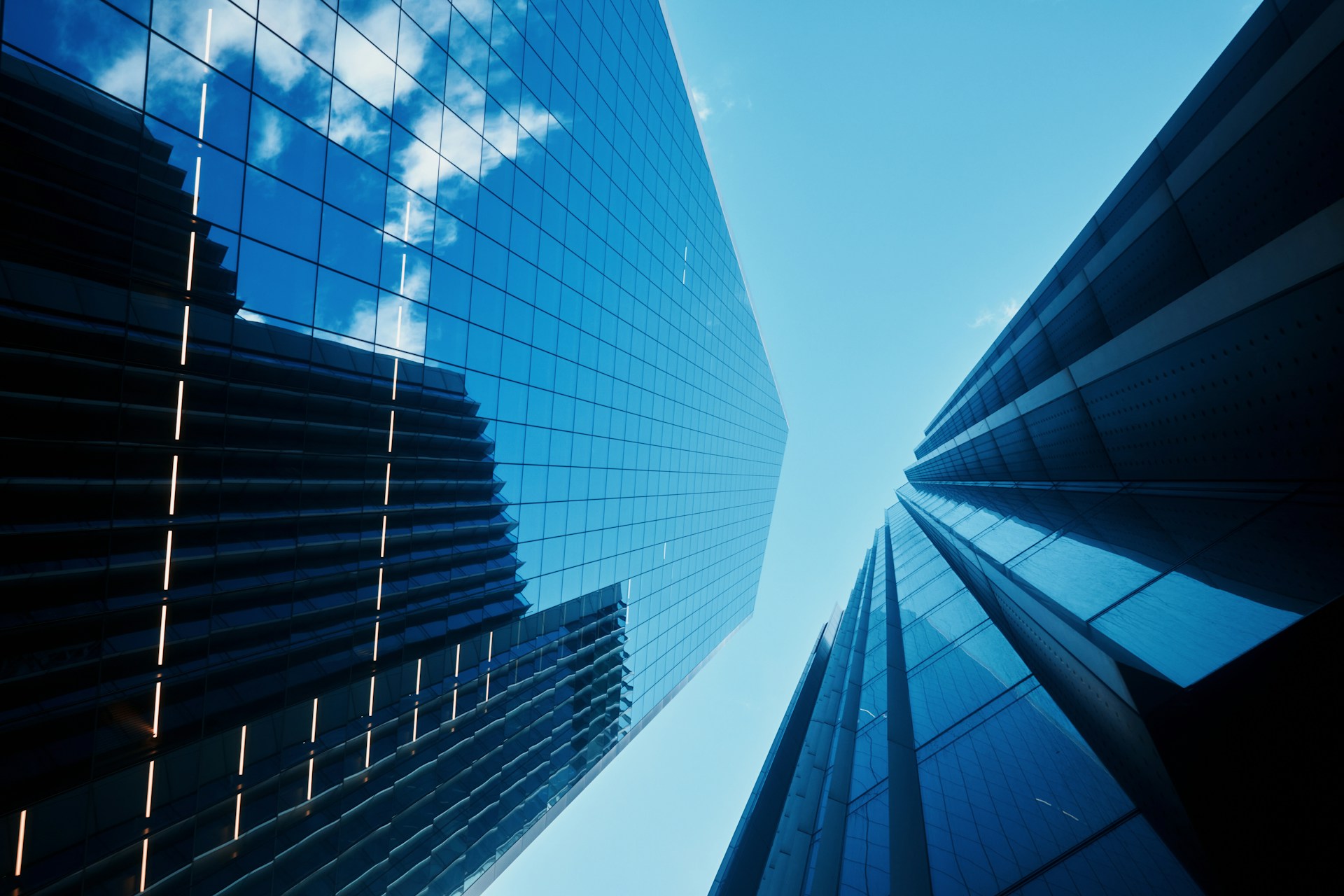Modern glass office buildings viewed from below, representing the UK financial services sector and regulatory reform.