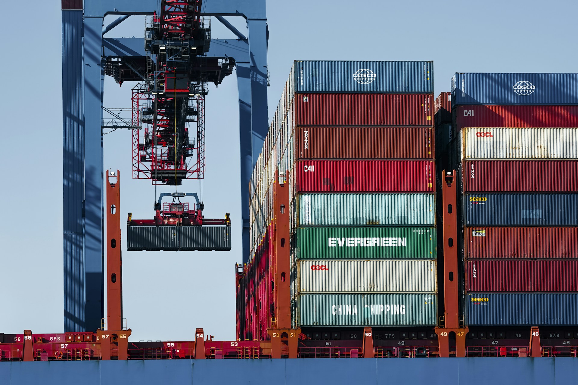 Cargo containers being handled at a shipping terminal, illustrating international trade and export opportunities for businesses.