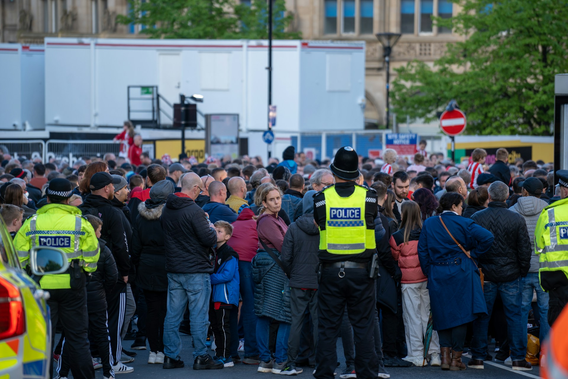 Police officers monitoring a large crowd outside a public venue, illustrating public safety and security considerations at busy events.