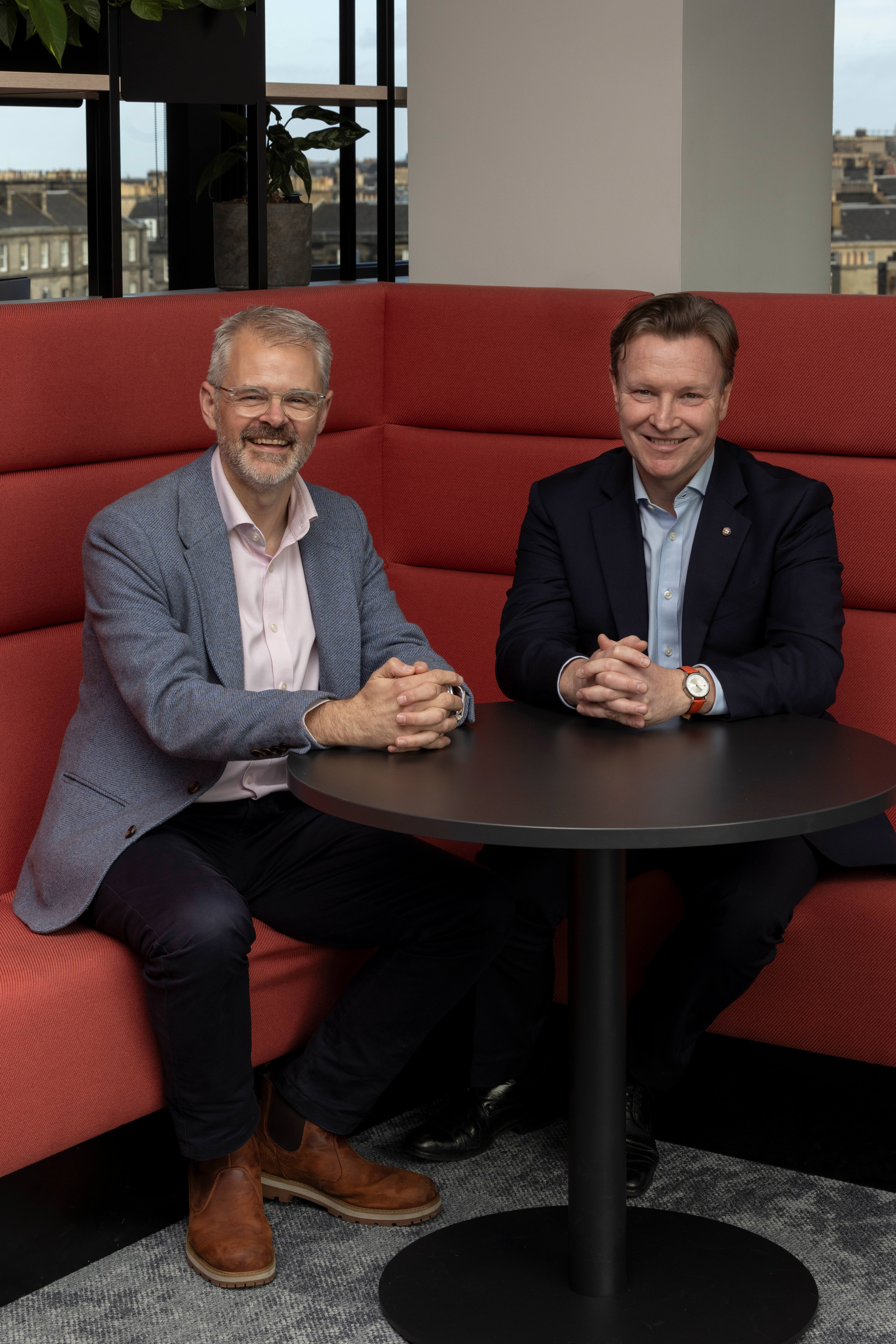 Chris Harte and Neil Kennedy seated in the MFMac Edinburgh office following the firm's announcement of strong, sustainable growth in profits and revenue.