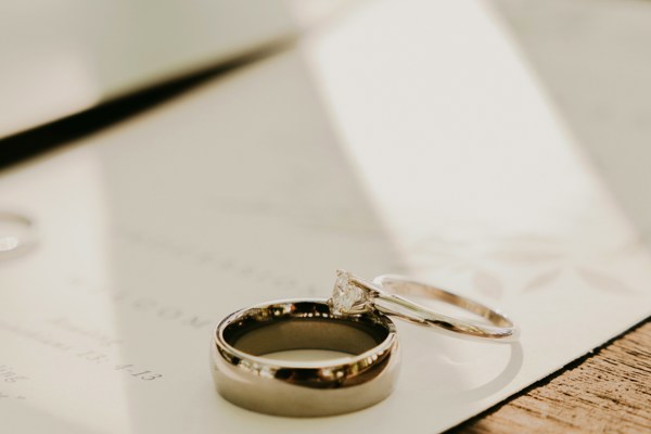 Close-up of two wedding rings resting on a document, symbolising marriage, divorce and family law matters.