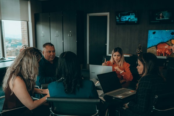 Diverse group of professionals meeting in a modern office to discuss workplace policies and employment matters.