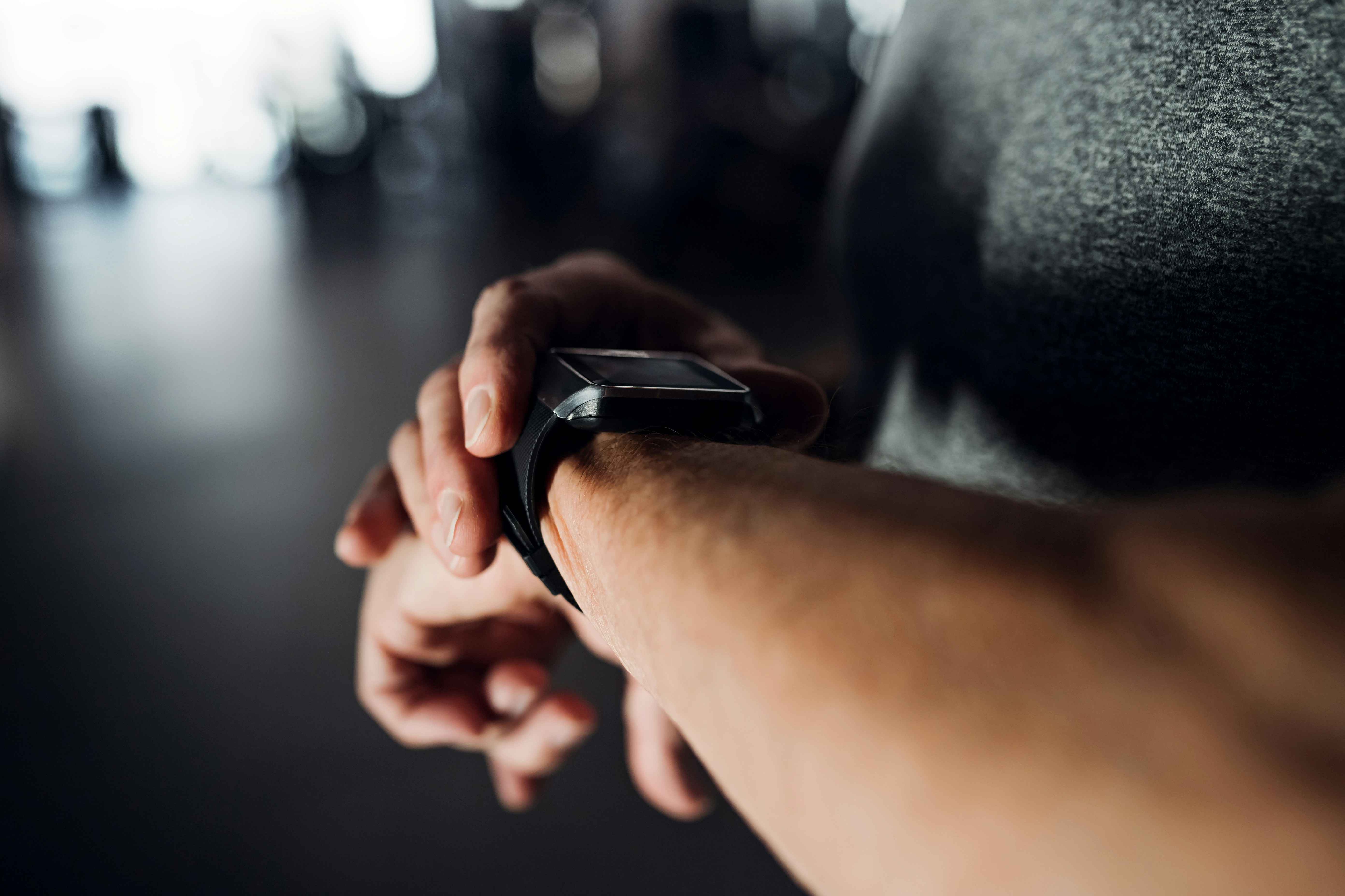 Person wearing a smartwatch displaying health and activity data, illustrating the relationship between wearable technology, wellbeing information and health data.