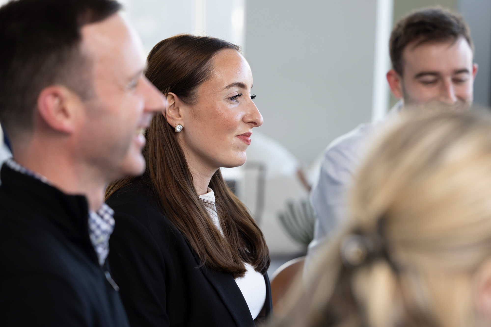 Group of colleagues seated around a table during a workplace discussion.