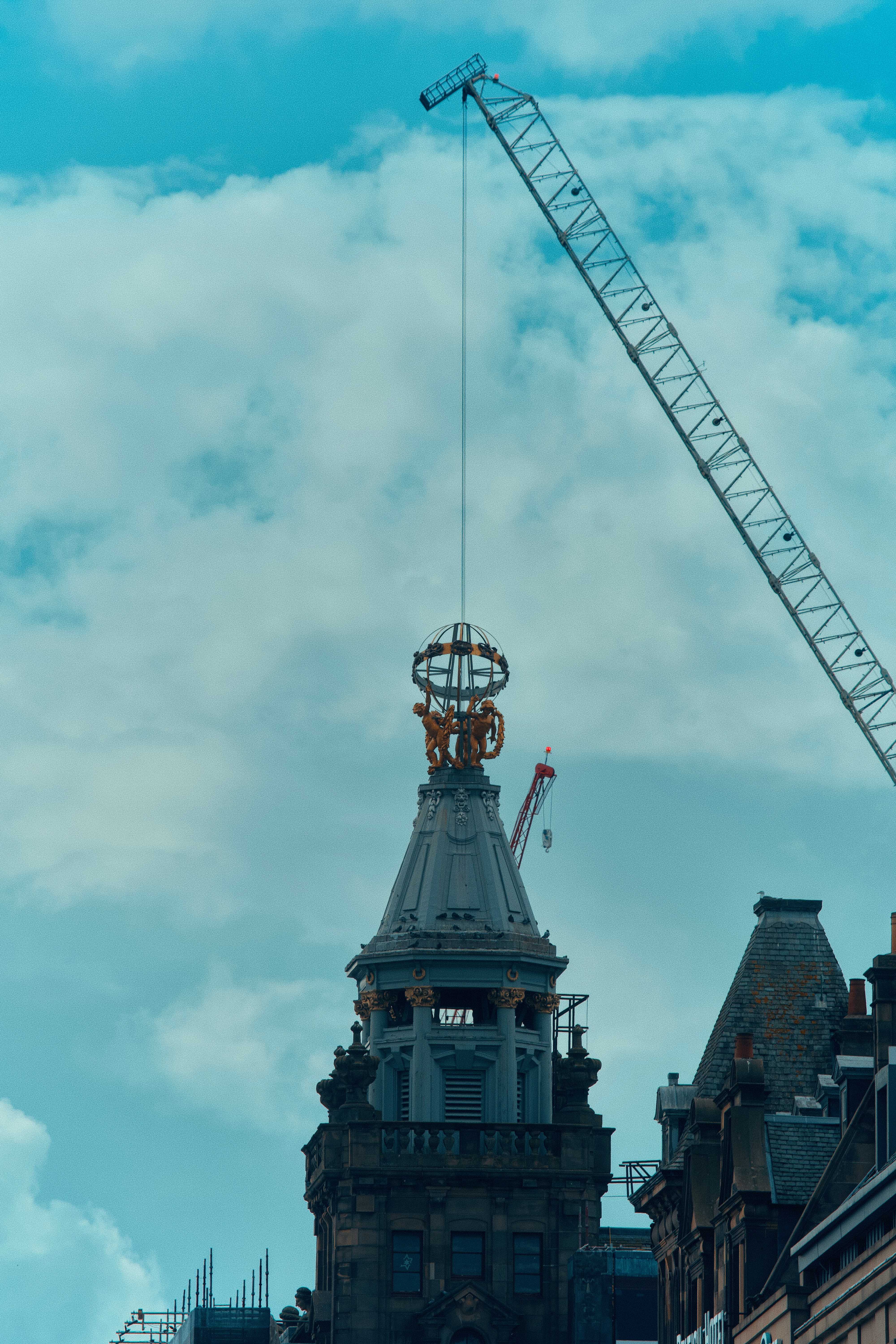 Crane operating above a historic city building.