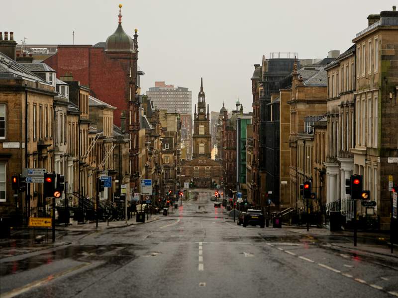 Rainy view of a UK city street with historic buildings, reflecting uncertainty in the commercial real estate market.