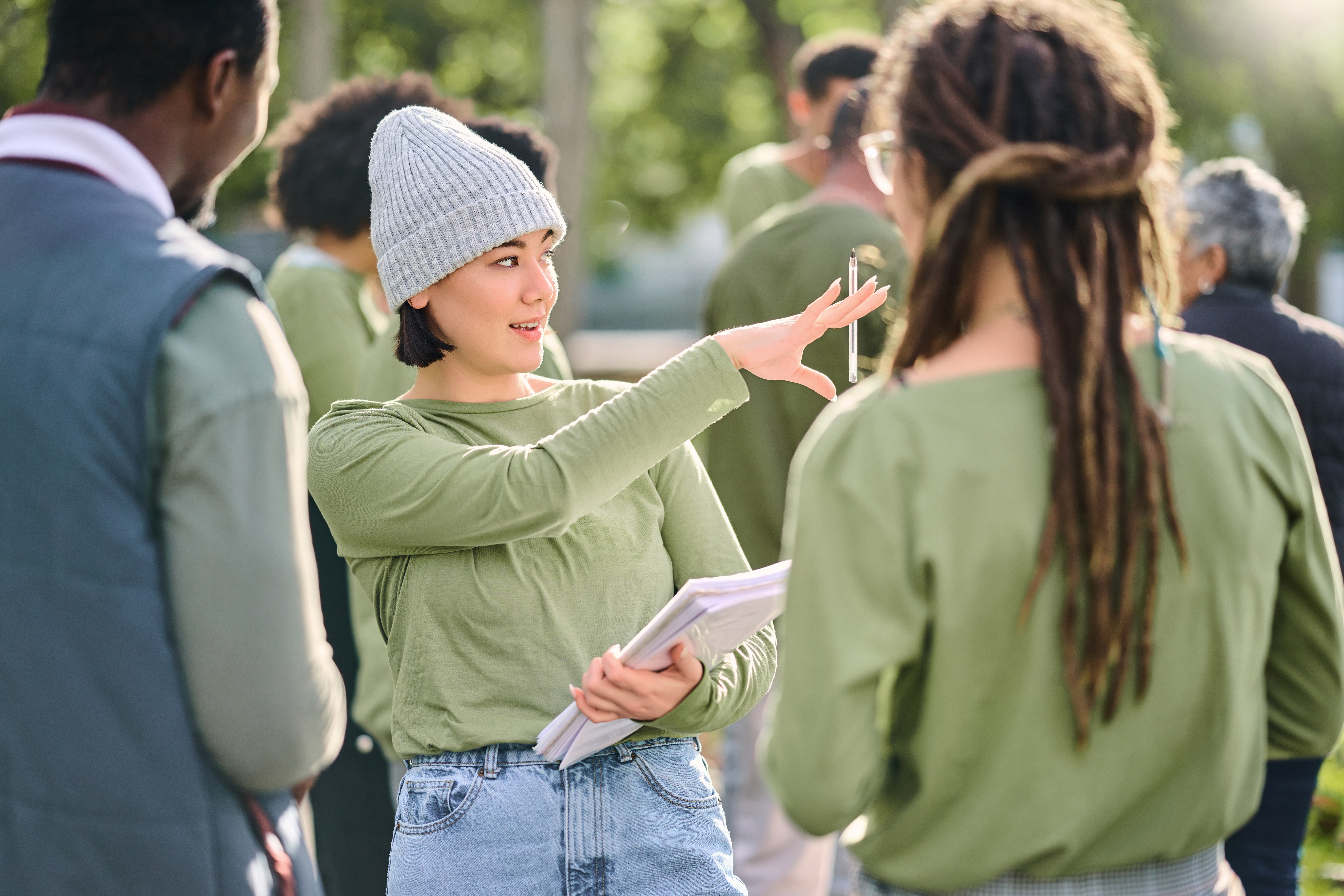 Group of people gathered outdoors, talking and sharing information as part of a community or charity activity.