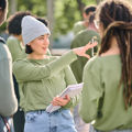 Group of people gathered outdoors, talking and sharing information as part of a community or charity activity.