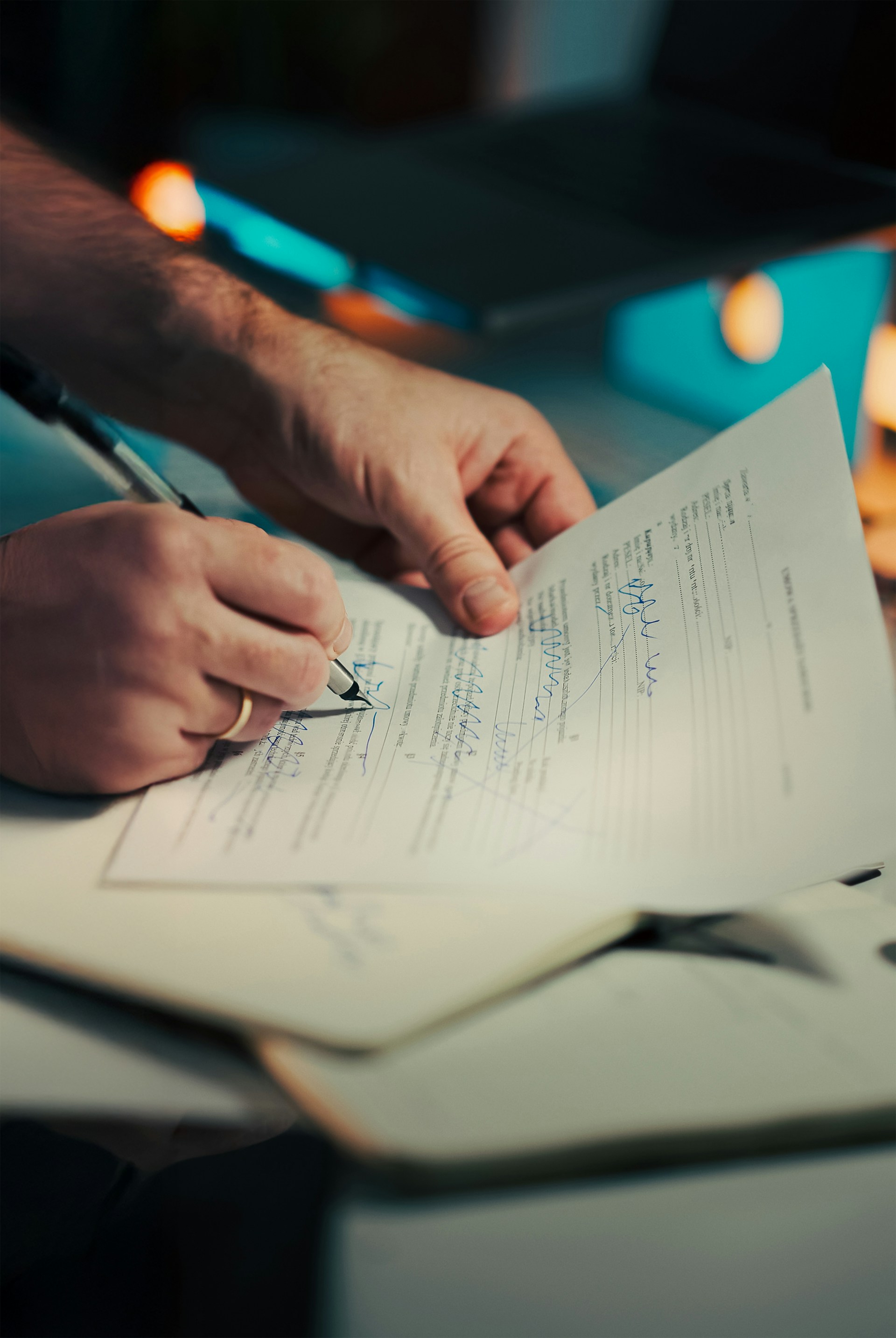 Close-up of hands signing a printed legal document with a pen, illustrating the preparation and execution of formal written notices.