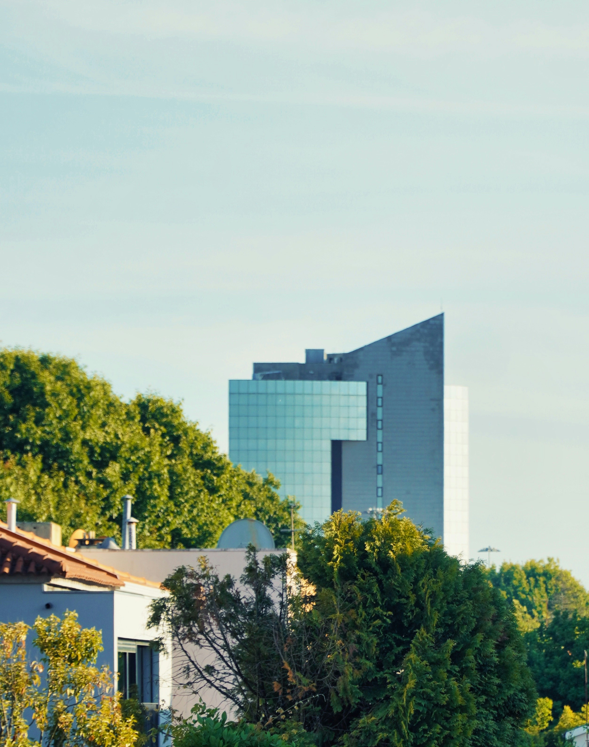 Modern building surrounded by trees and greenery.