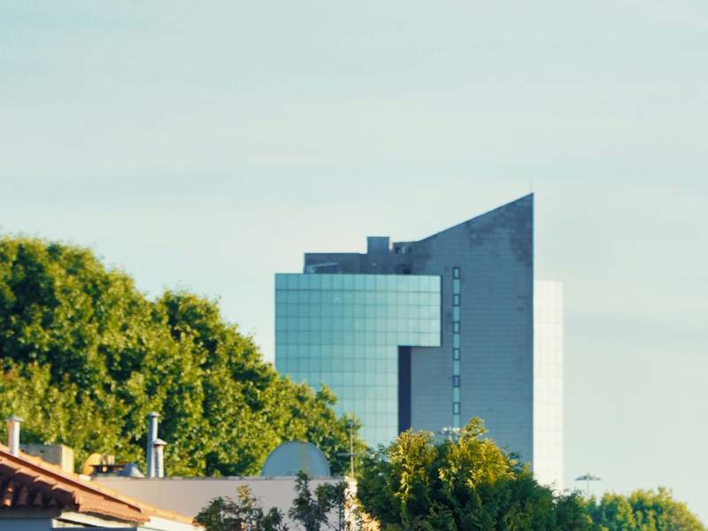 Modern building surrounded by trees and greenery.