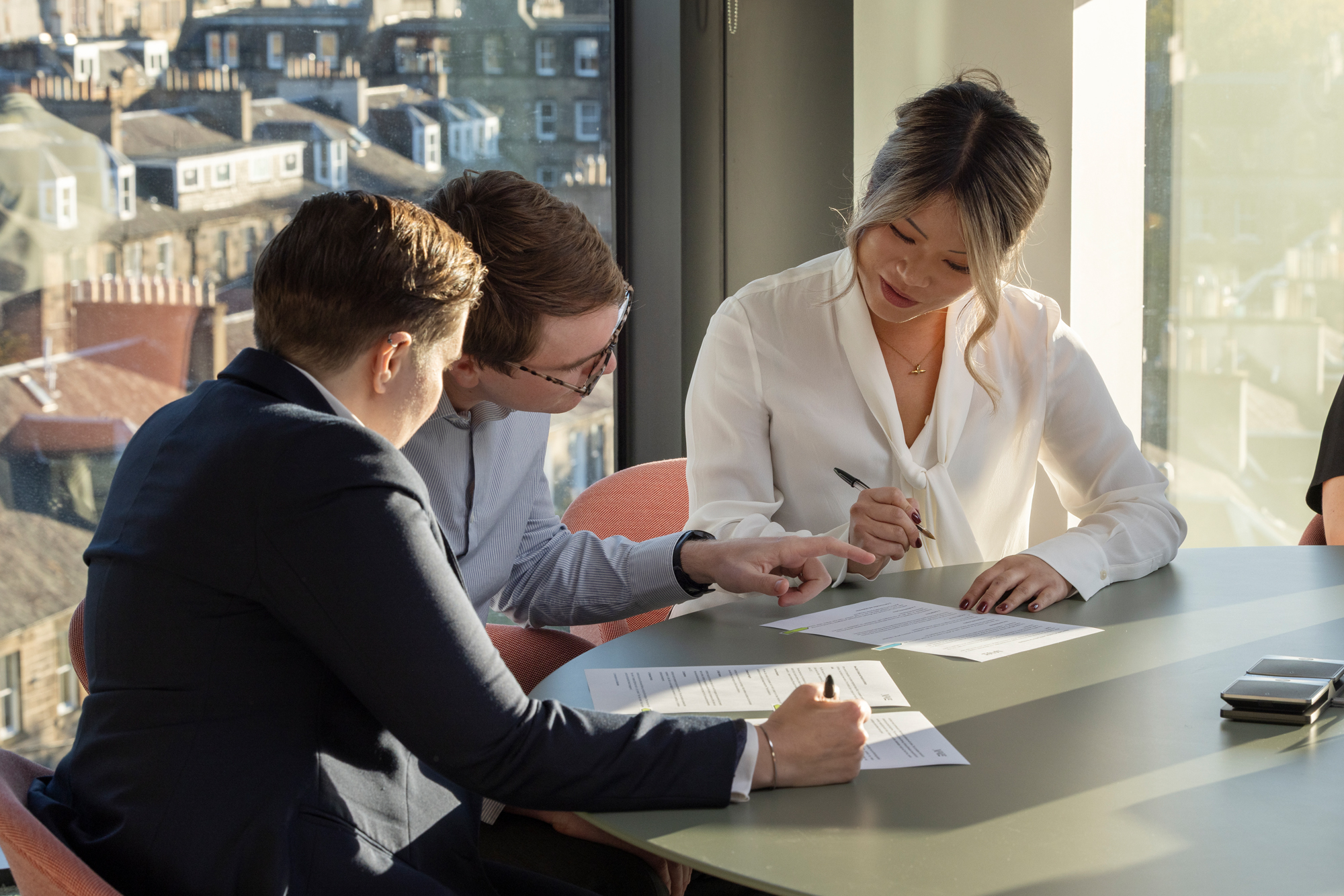 Colleagues reviewing documents in a meeting room.