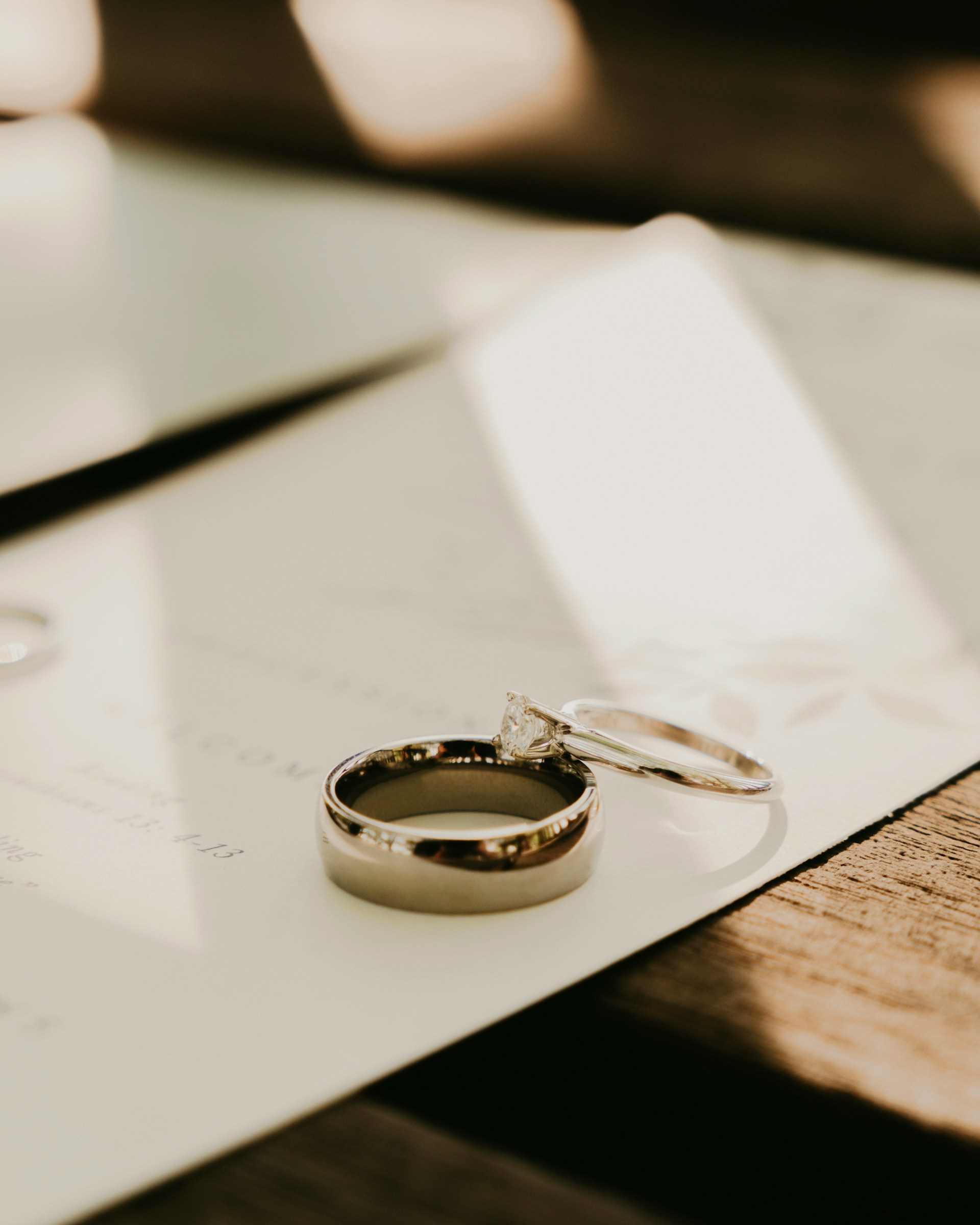 Wedding rings resting on a document, symbolising a marriage agreement and legal considerations surrounding nuptial arrangements.