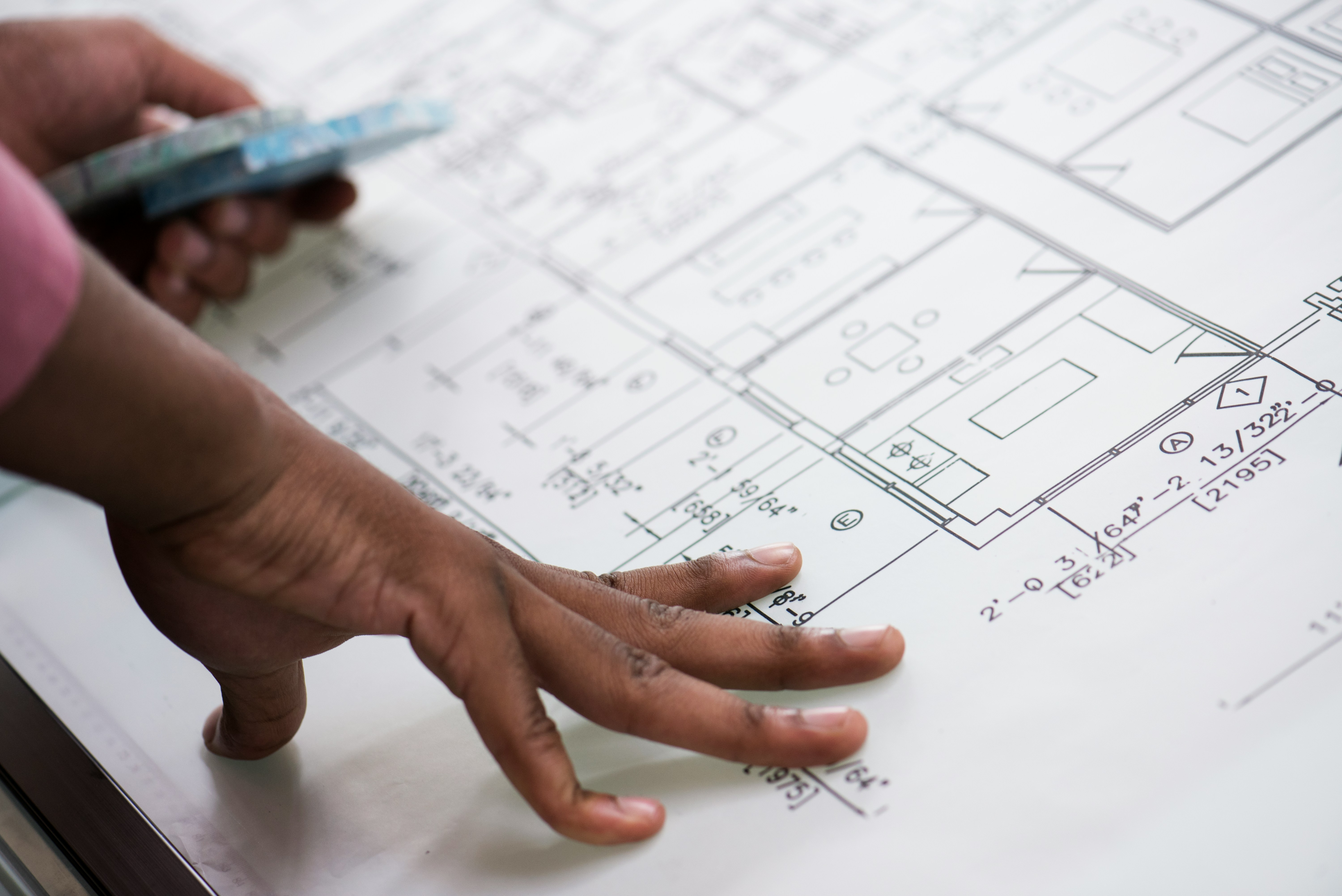 Person reviewing architectural plans and construction drawings.