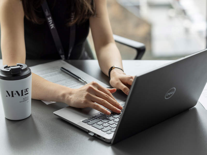 Person typing on a laptop during an employment law webinar