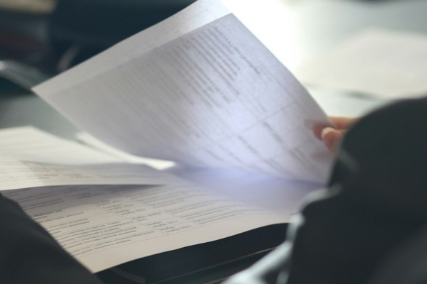 Person reviewing workplace documents during a meeting, representing employment law updates, compliance and workplace policy developments.
